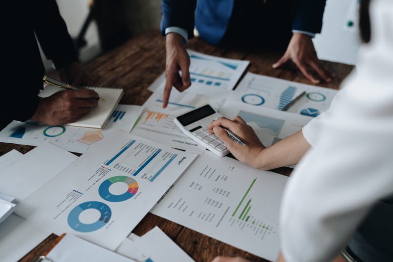 Team analysiert Diagramme und Unterlagen am Tisch