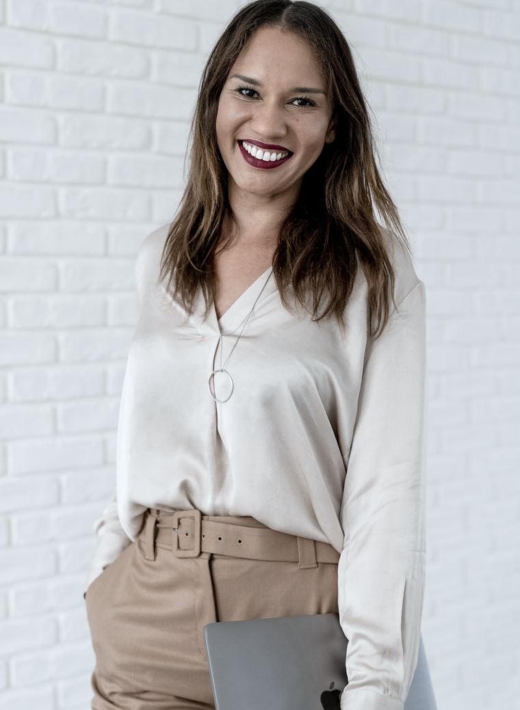 Fatou Wane, Verhandlungsstrategin, vor einer weißen Backsteinwand